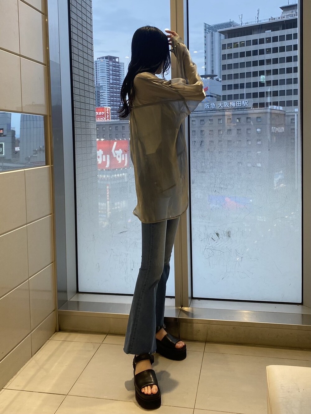 ブラック系のサンダル、グレー系のシャツ/ブラウス、ブルー系のデニムパンツを着用したレディースの夏コーディネートの3枚目の写真