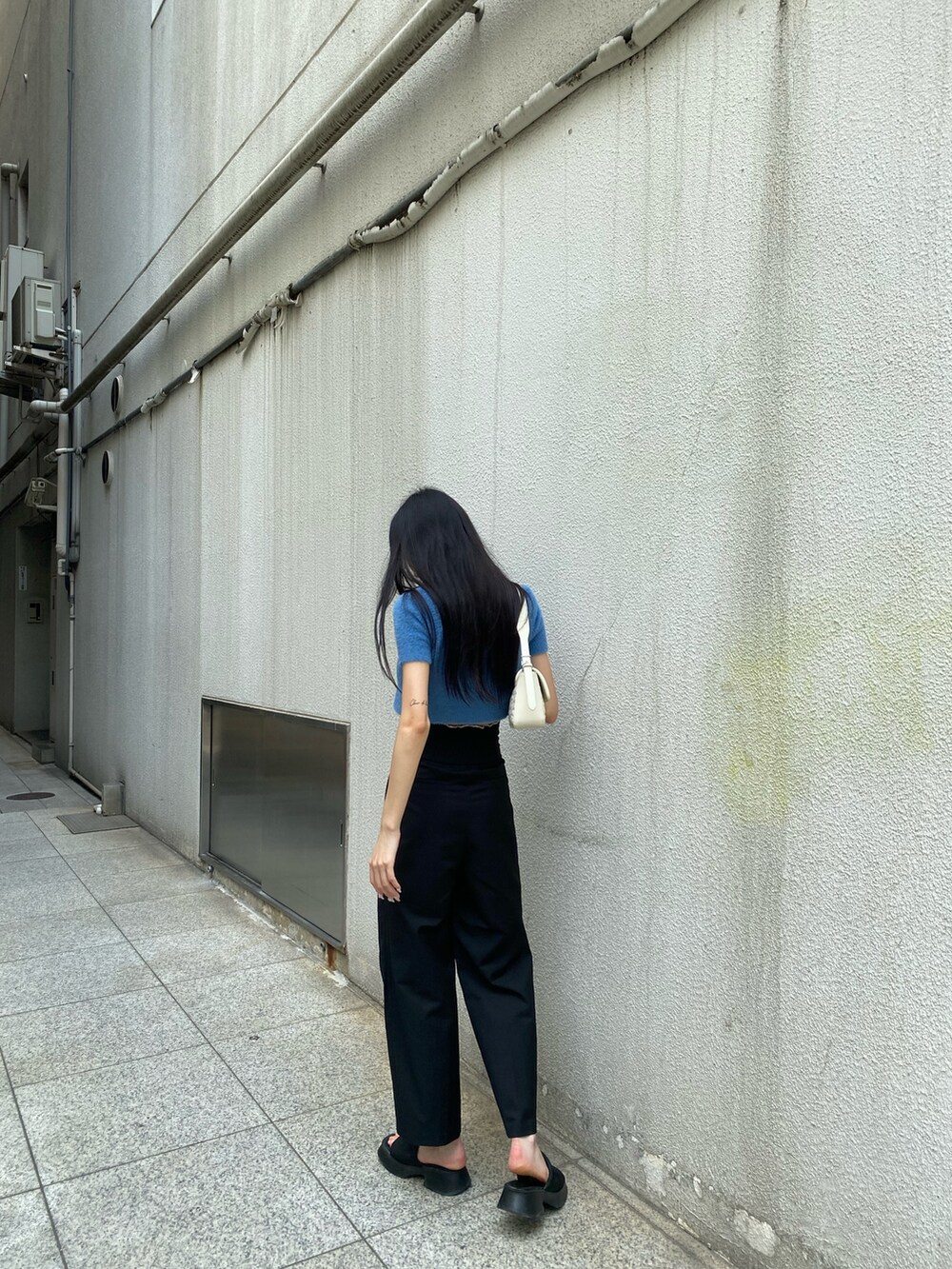 ブラック系のその他パンツ、ホワイト系のハンドバッグ、ブルー系のニット/セーターを着用したレディースの夏コーディネートの4枚目の写真