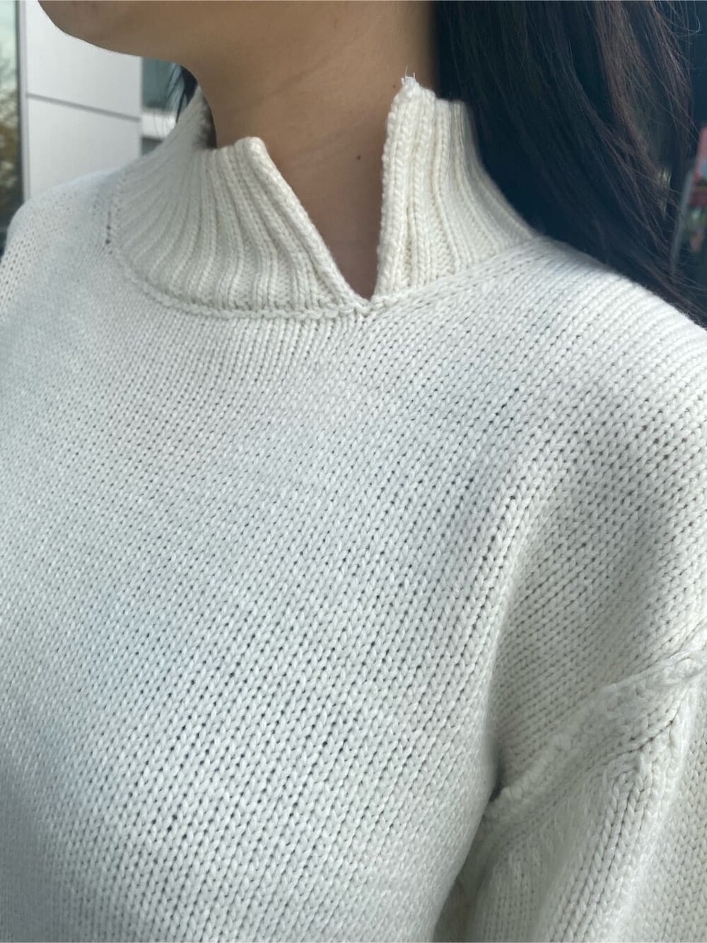 ブラック系のデニムパンツ、ホワイト系のニット/セーター、グリーン系のチェスターコートを着用したレディースの秋コーディネートの6枚目の写真