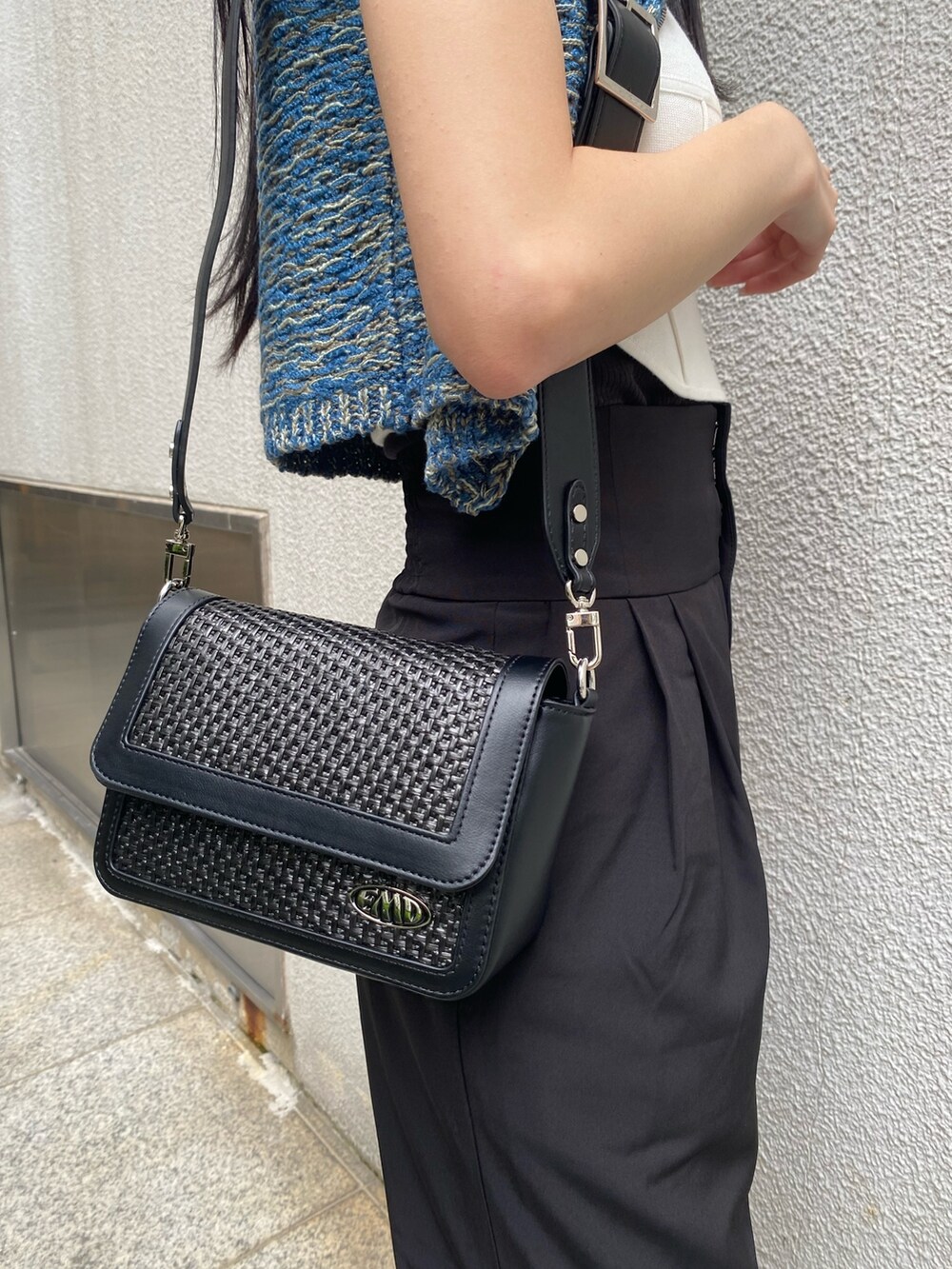 ホワイト系のニット/セーター、ブラック系のその他パンツ、ブラック系のショルダーバッグを着用したレディースの夏コーディネートの7枚目の写真