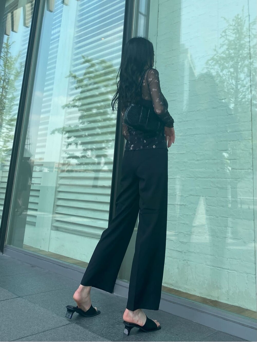 ブラック系のハンドバッグ、ブラック系のその他パンツ、ブラック系のサンダルを着用したレディースの夏コーディネートの2枚目の写真