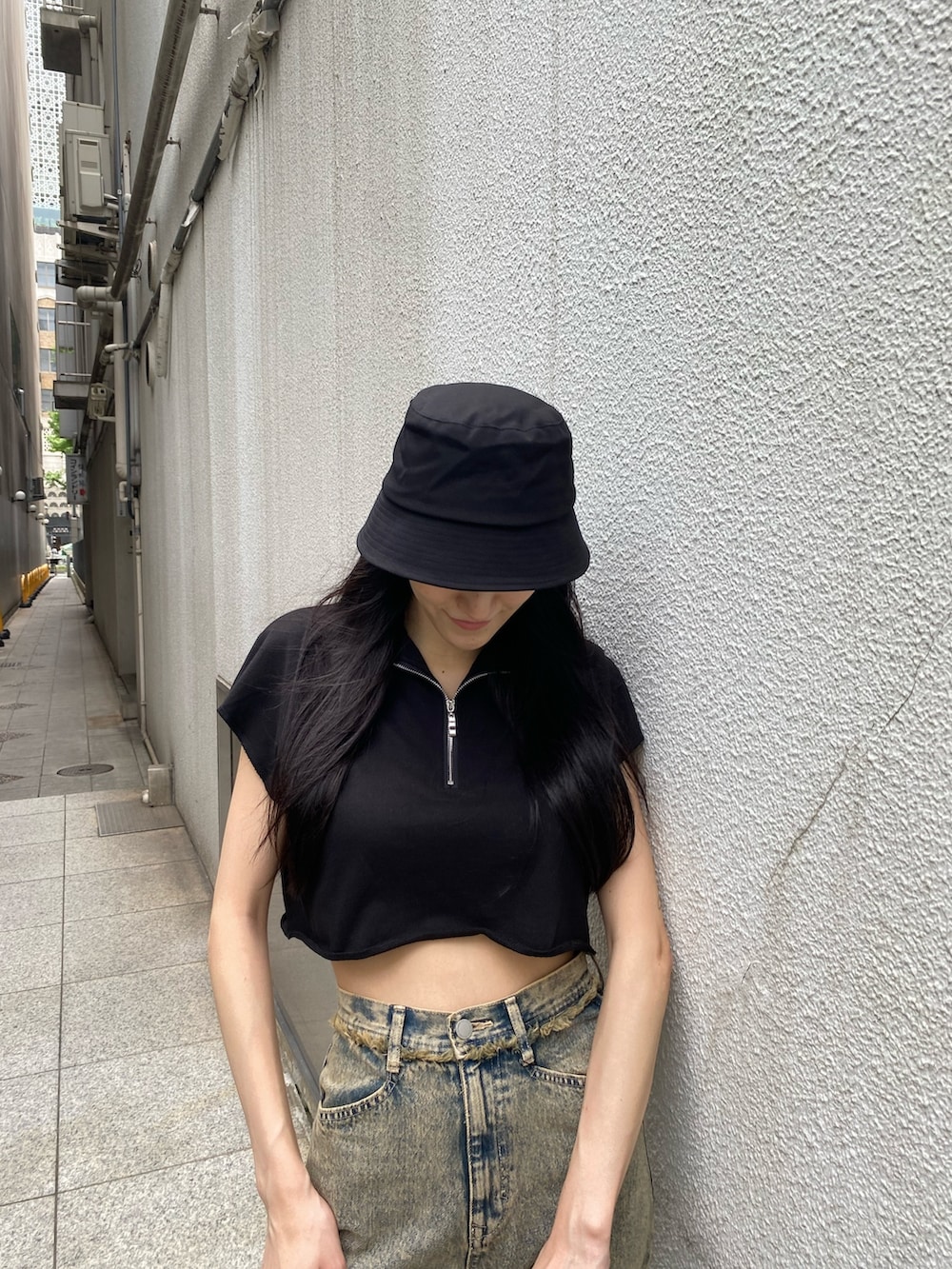 ブラック系のTシャツ/カットソー、ブラック系のハンドバッグ、ベージュ系のデニムパンツを着用したレディースの夏コーディネートの5枚目の写真