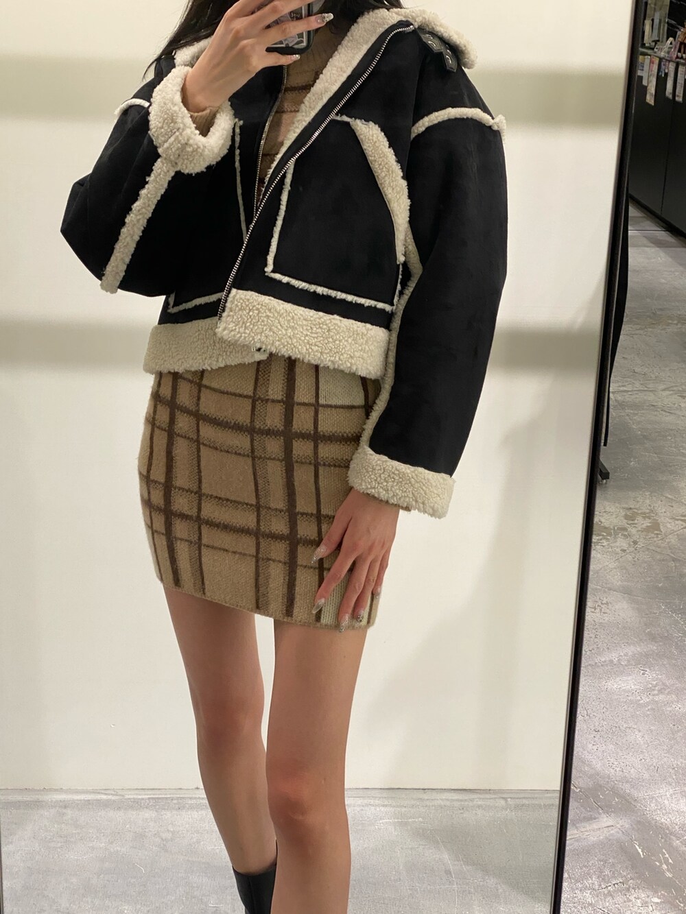 ベージュ系のスカート、ベージュ系のニット/セーター、ブラック系のブーツを着用したレディースの冬コーディネートの3枚目の写真