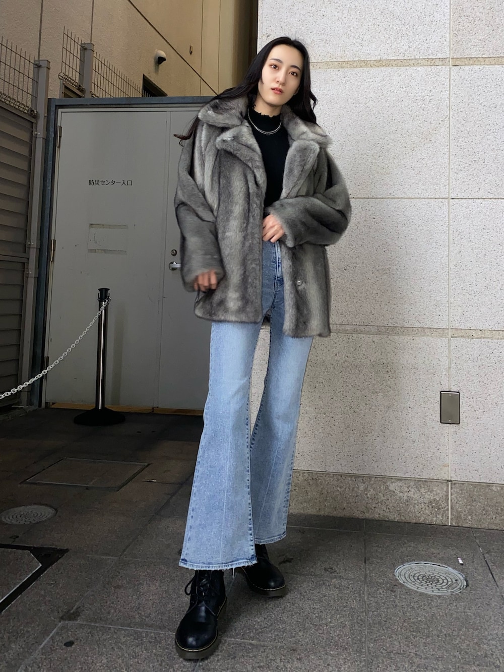 ブラック系のニット/セーター、グレー系のその他アウター、ブルー系のデニムパンツを着用したレディースの冬コーディネートの2枚目の写真