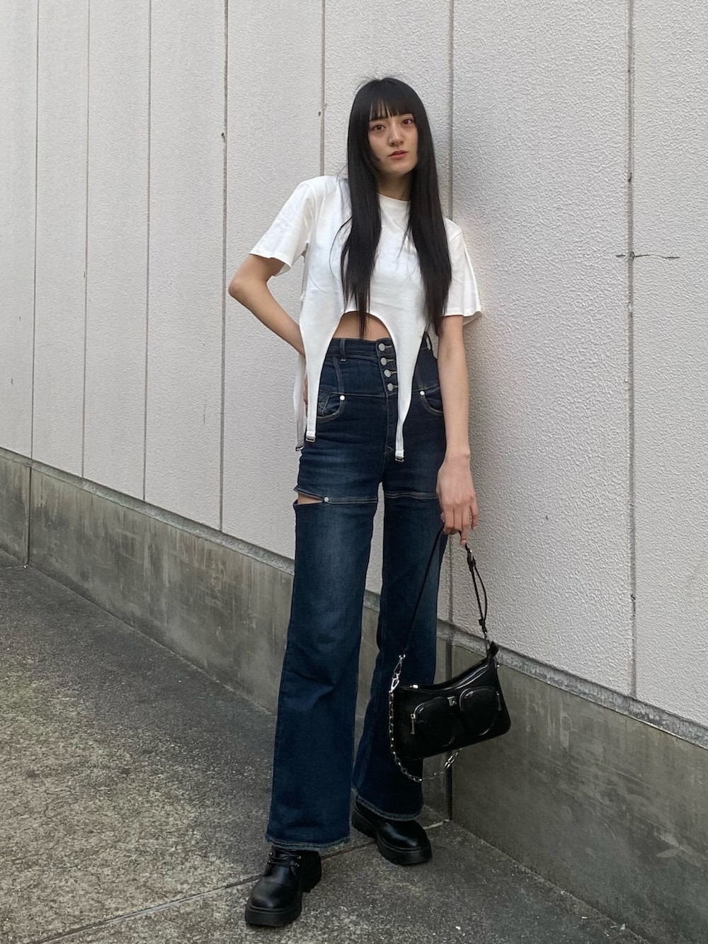 ブルー系のデニムパンツ、ブラック系のショルダーバッグ、ホワイト系のTシャツ/カットソーを着用したレディースの春コーディネートの2枚目の写真