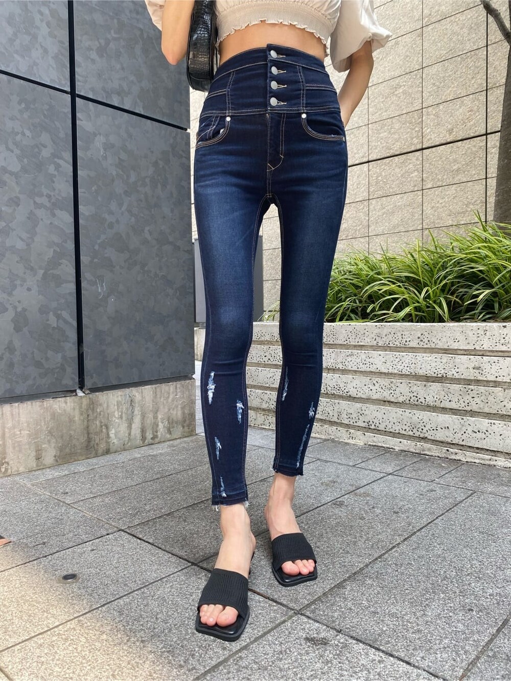 ブルー系のデニムパンツ、ホワイト系のTシャツ/カットソー、ブラック系のサンダルを着用したレディースの夏コーディネートの5枚目の写真