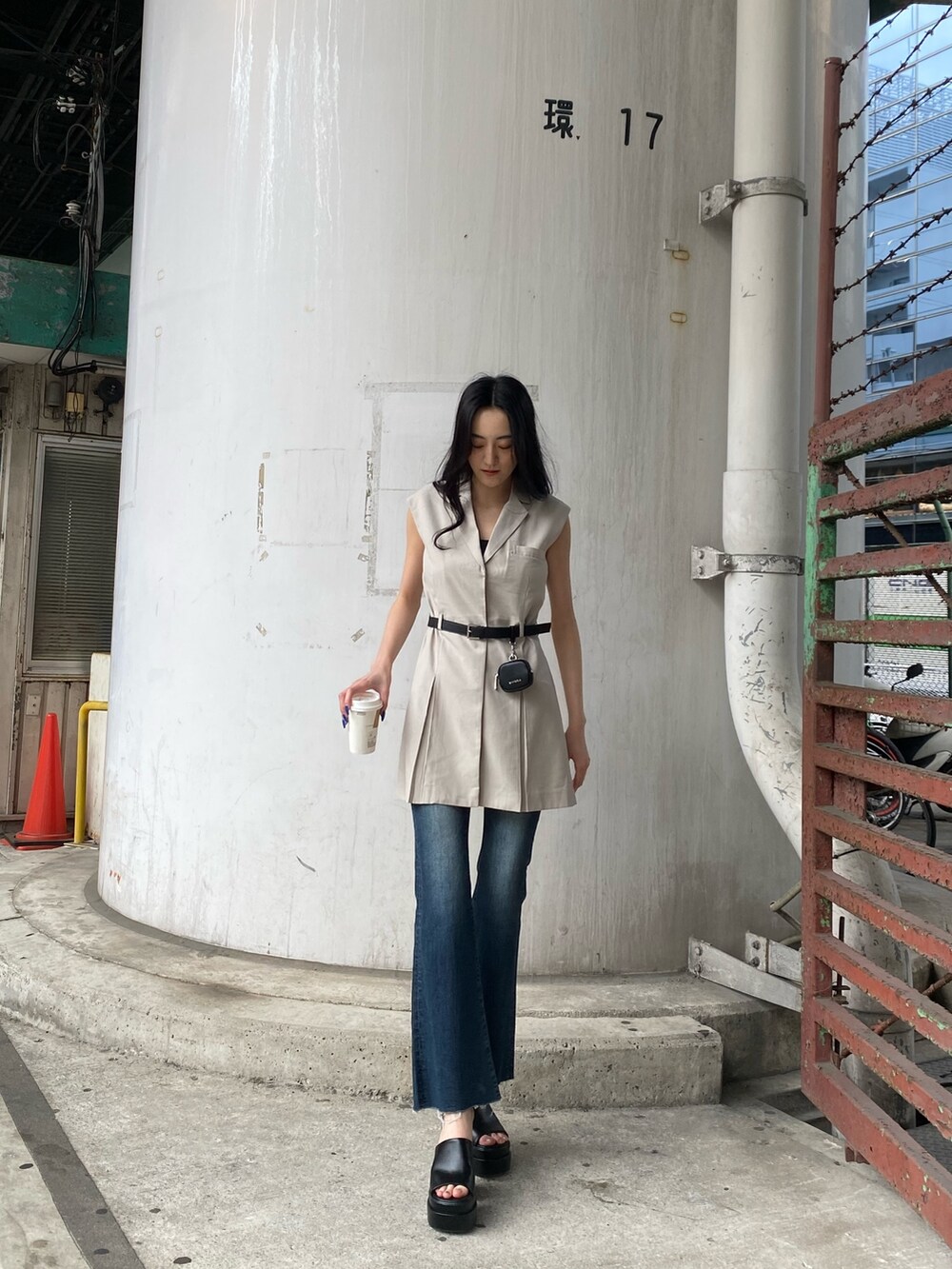 ホワイト系のワンピース、ブルー系のデニムパンツ、ブラック系のサンダルを着用したレディースの春コーディネートの5枚目の写真