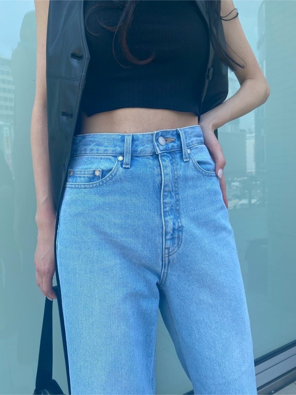 ブルー系のデニムパンツ、ブラック系のワンピース、ベージュ系のスリッポンを着用したレディースの夏コーディネートの7枚目の写真