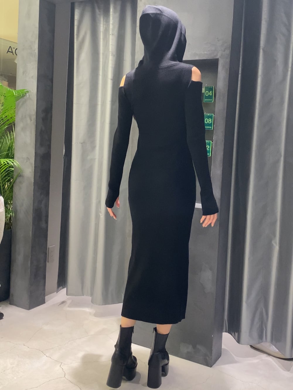 ブラック系のワンピース、ブラック系のブーツを着用したレディースの秋コーディネートの4枚目の写真