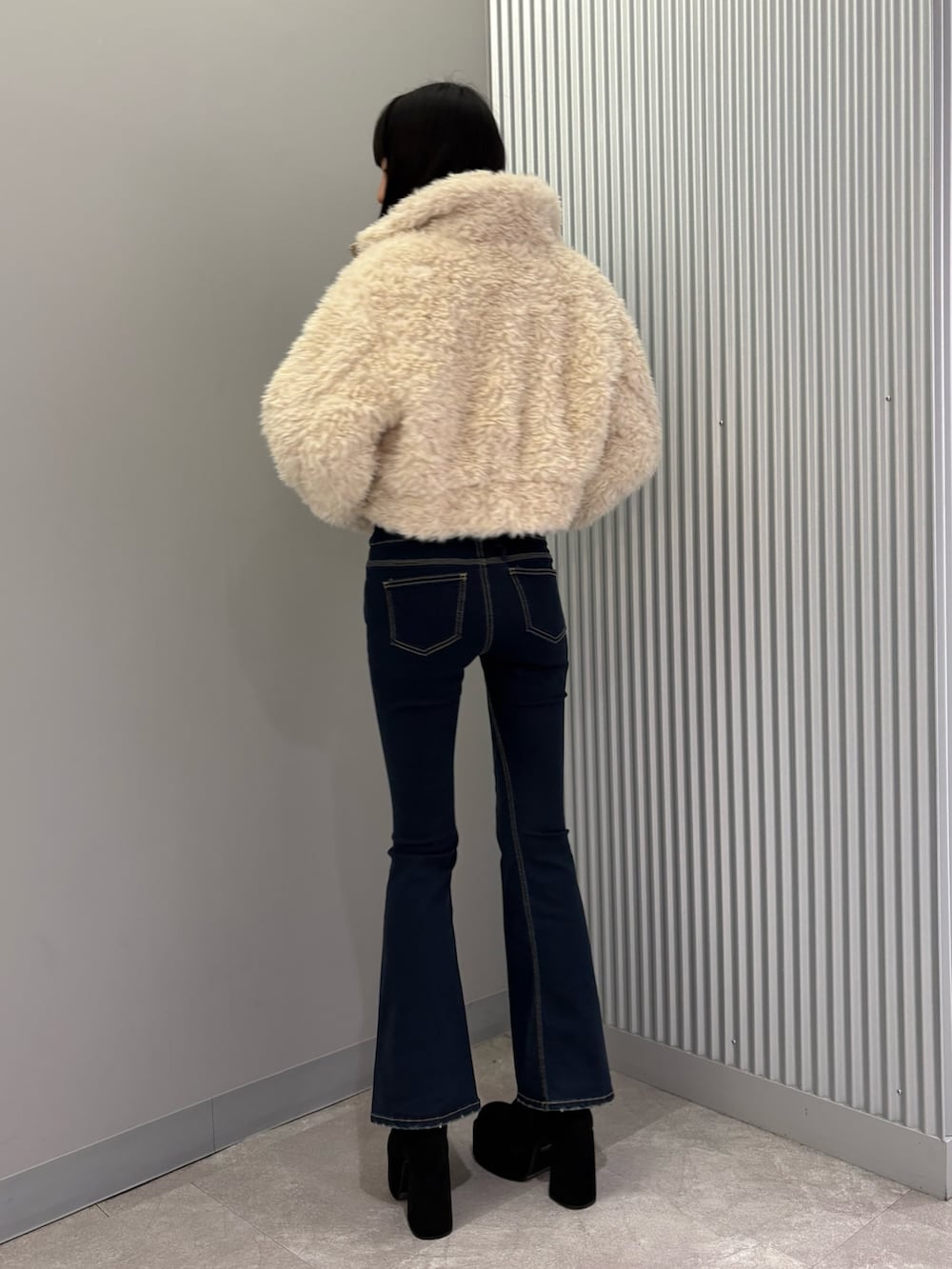 ブルー系のデニムパンツ、ホワイト系のブルゾン、グレー系のニット/セーターを着用したレディースの秋コーディネートの3枚目の写真