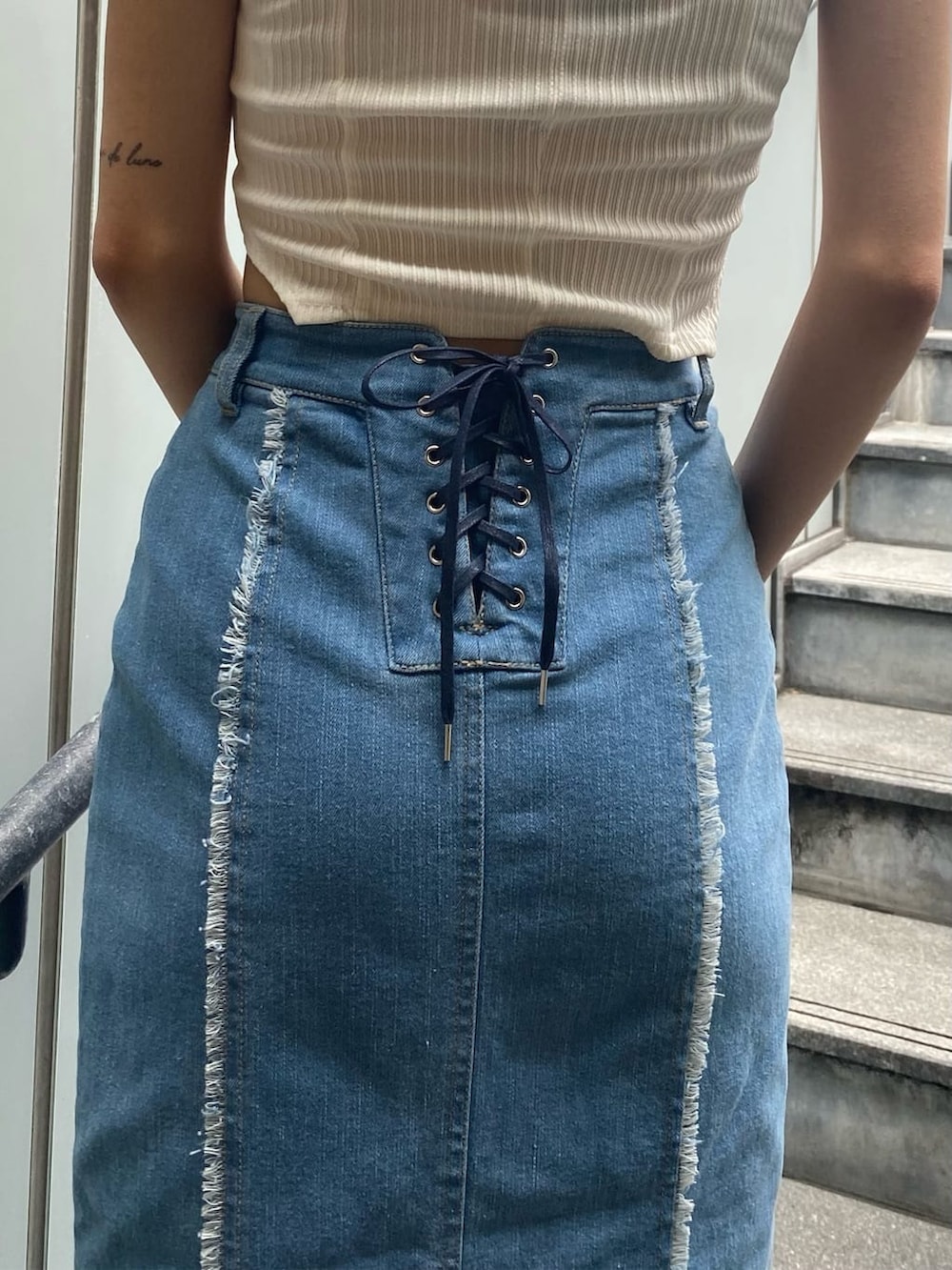 ブルー系のスカート、ホワイト系のタンクトップ、ブラック系のサンダルを着用したレディースの夏コーディネートの5枚目の写真