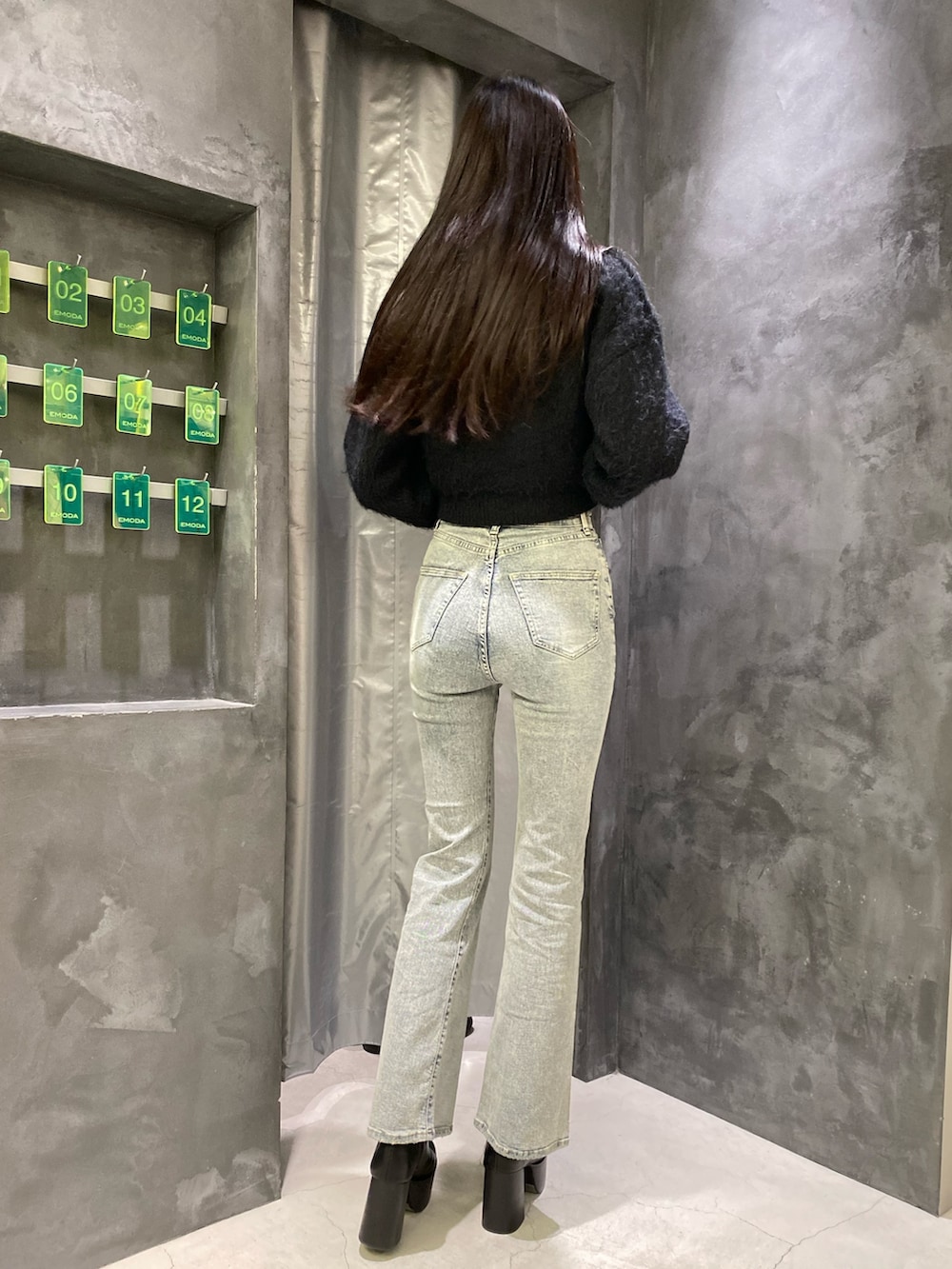 ブルー系のデニムパンツ、ブラック系のニット/セーター、ブラック系のブーツを着用したレディースの秋コーディネートの9枚目の写真