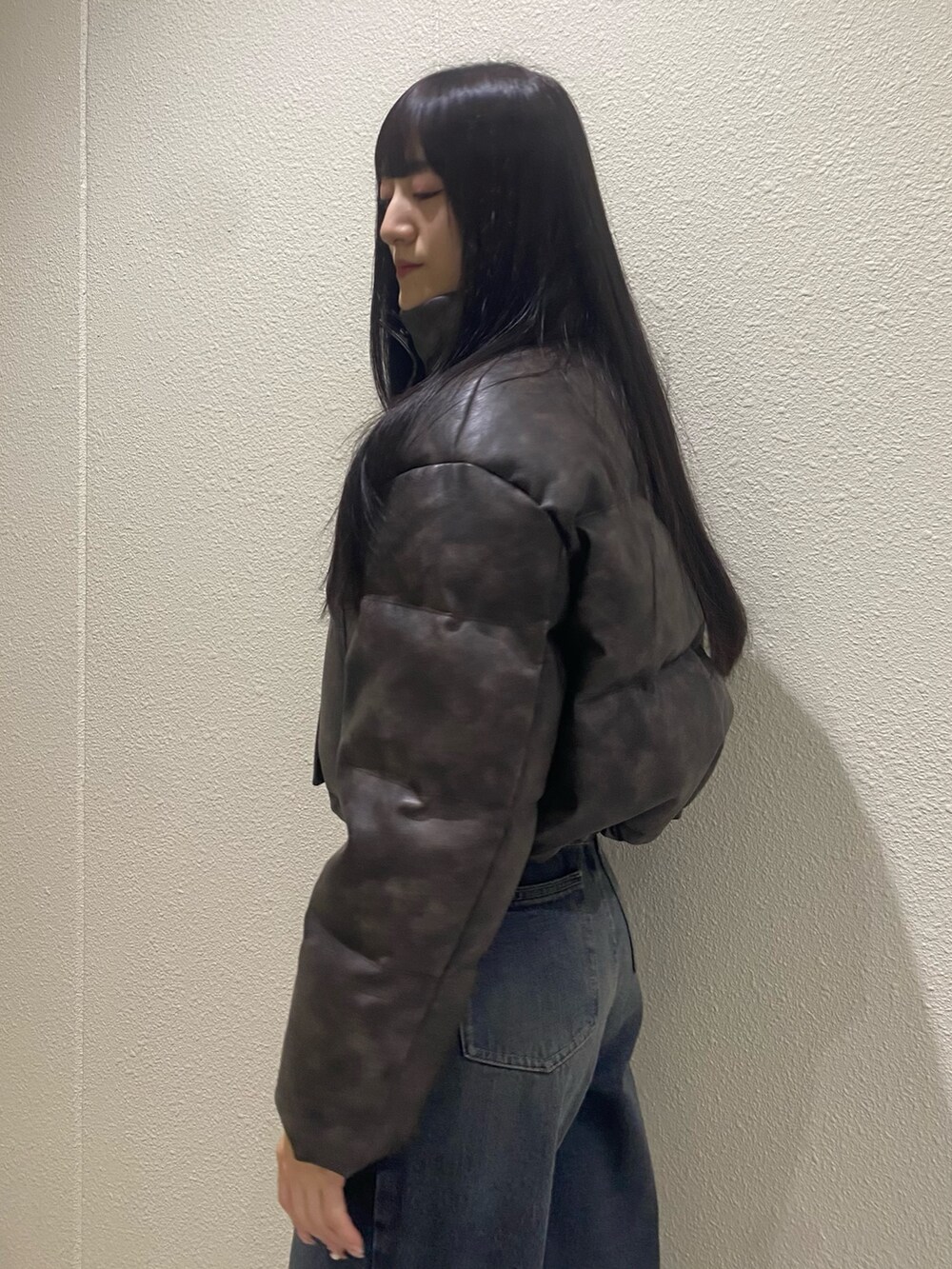 ブルー系のデニムパンツ、ブラウン系のダウンジャケット/コート、ブラック系のブーツを着用したレディースの冬コーディネートの6枚目の写真