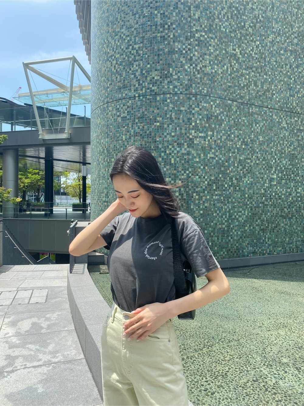 ホワイト系のデニムパンツ、ブラック系のサンダル、ブラック系のハンドバッグを着用したレディースの夏コーディネートの8枚目の写真