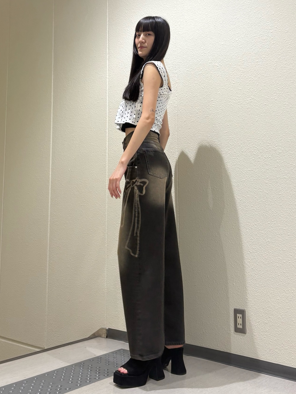 ブラック系のデニムパンツ、ホワイト系のタンクトップ、ブラック系のTシャツ/カットソーを着用したレディースの夏コーディネートの3枚目の写真