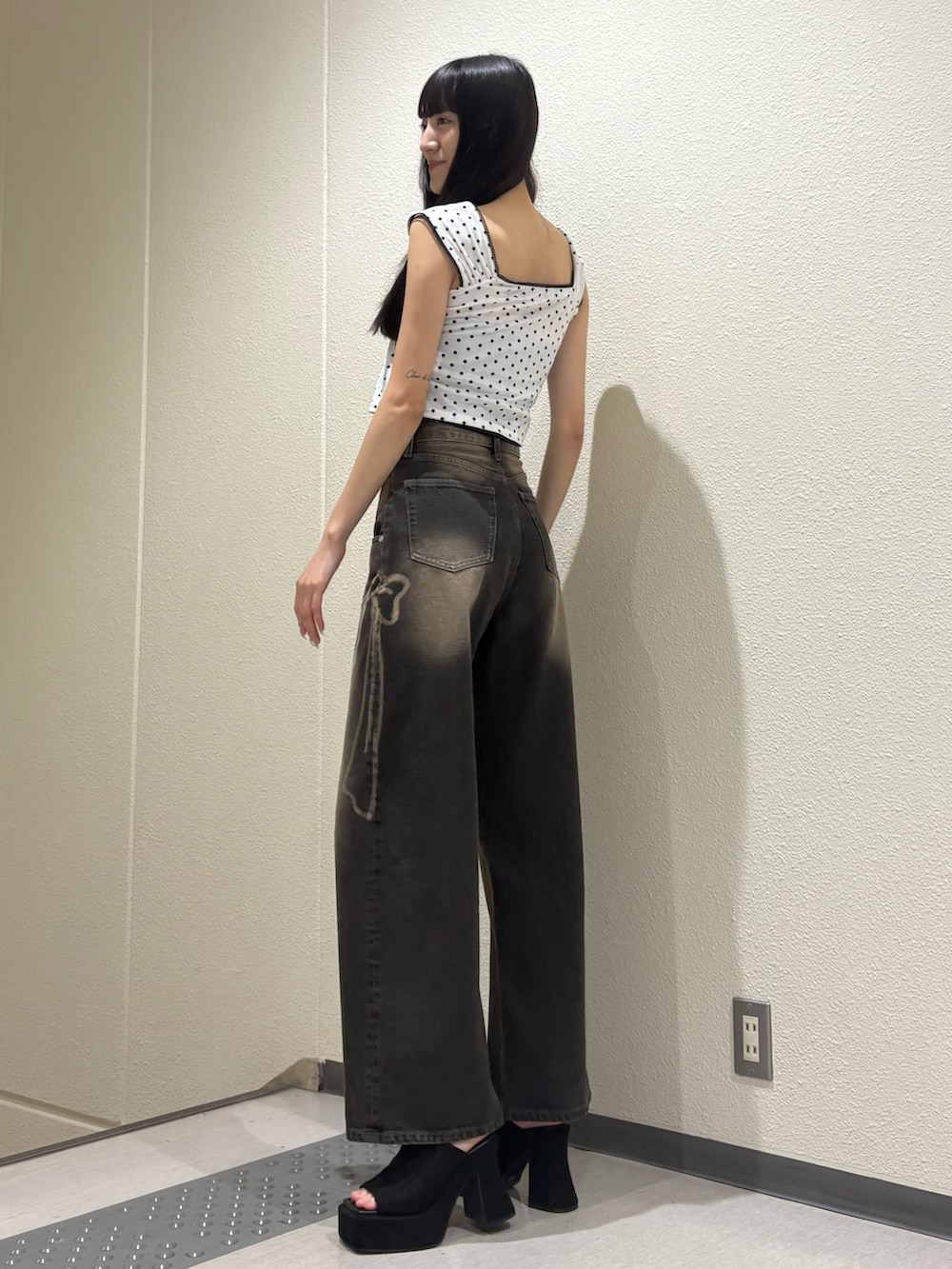 ブラック系のデニムパンツ、ホワイト系のタンクトップ、ブラック系のTシャツ/カットソーを着用したレディースの夏コーディネートの4枚目の写真