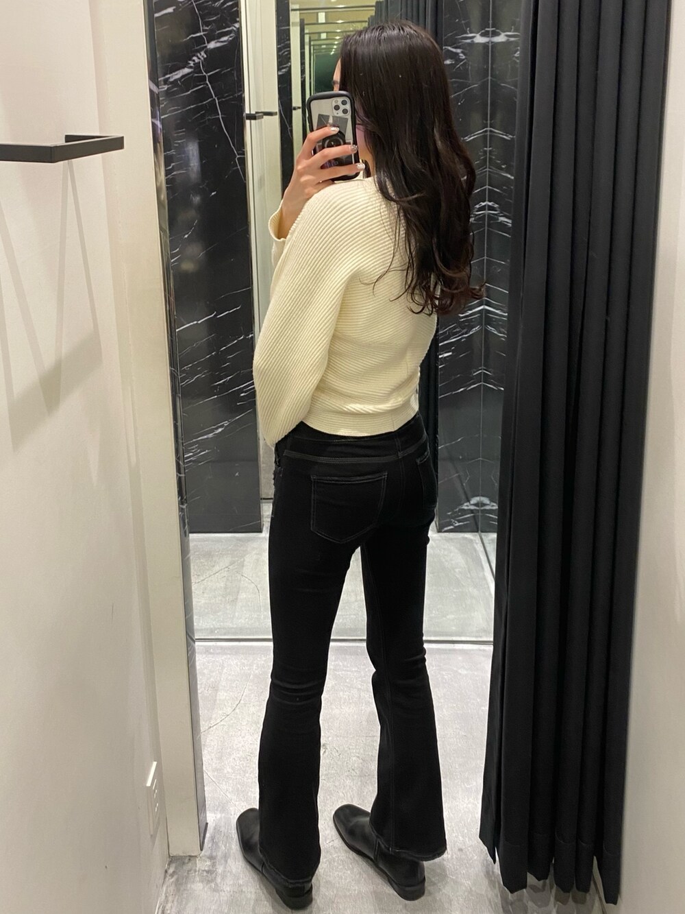 ホワイト系のニット/セーター、ブラック系のデニムパンツを着用したレディースの冬コーディネートの3枚目の写真