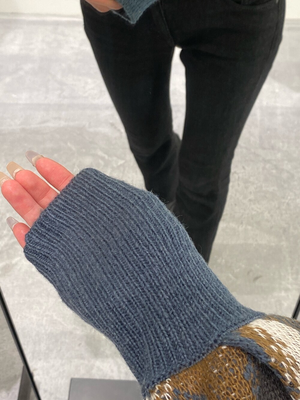 ベージュ系のハンドバッグ、ブラック系のデニムパンツ、ブルー系のニット/セーターを着用したレディースの秋コーディネートの6枚目の写真