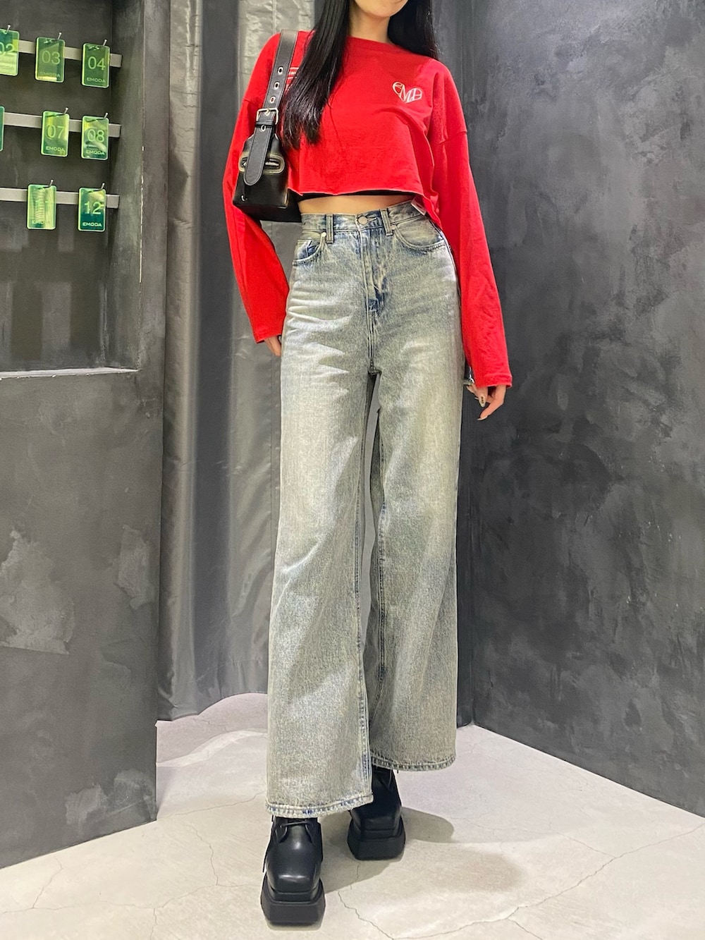 ブルー系のデニムパンツ、ブラック系のハンドバッグ、レッド系のTシャツ/カットソーを着用したレディースの秋コーディネートの5枚目の写真