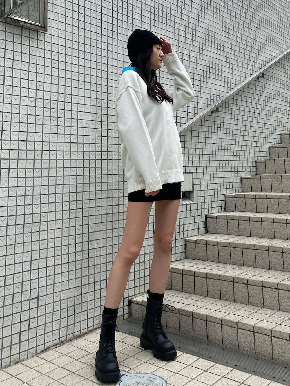 ブルー系のシャツ/ブラウス、ホワイト系のニット/セーター、ブラック系のスカートを着用したレディースの冬コーディネートの2枚目の写真