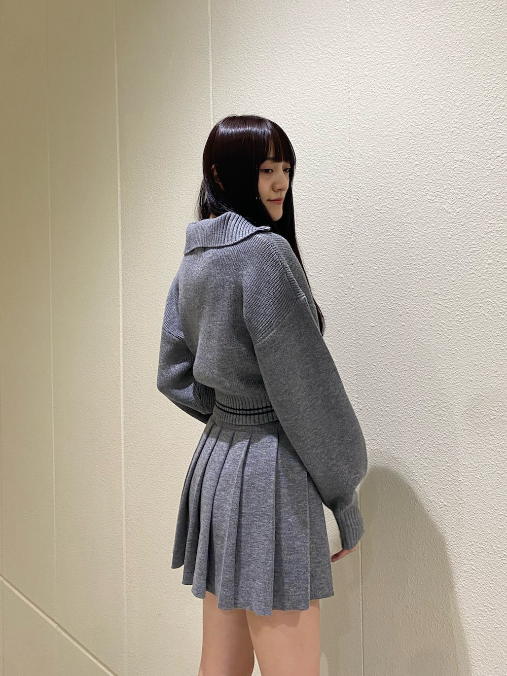 グレー系のニット/セーター、グレー系のスカート、その他のブーツを着用したレディースの秋コーディネートの6枚目の写真