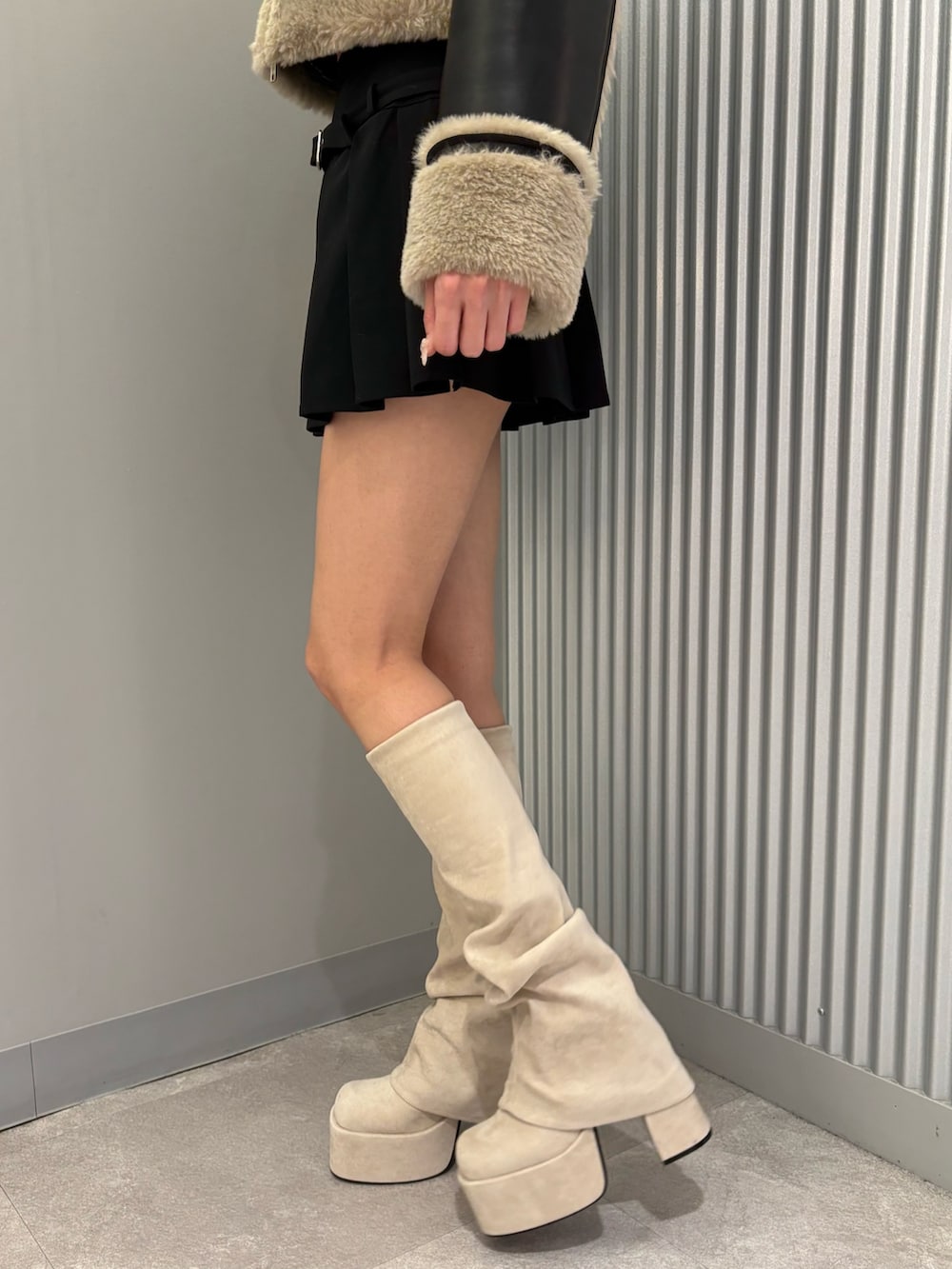 ブラック系のスカート、その他のブルゾン、ホワイト系のブーツを着用したレディースの秋コーディネートの10枚目の写真