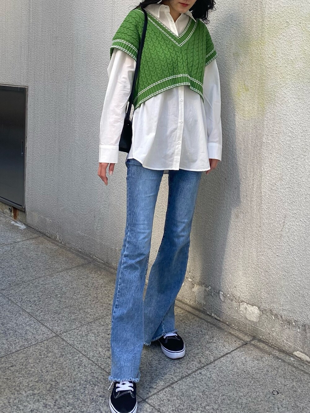 グリーン系のベスト、ホワイト系のシャツ/ブラウス、ブラック系のショルダーバッグを着用したレディースの冬コーディネートの4枚目の写真