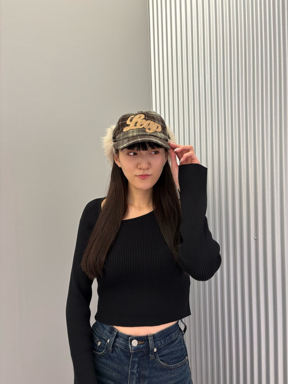 ブルー系のデニムパンツ、ブラック系のニット/セーター、ブラック系のスニーカーを着用したレディースの秋コーディネートの5枚目の写真