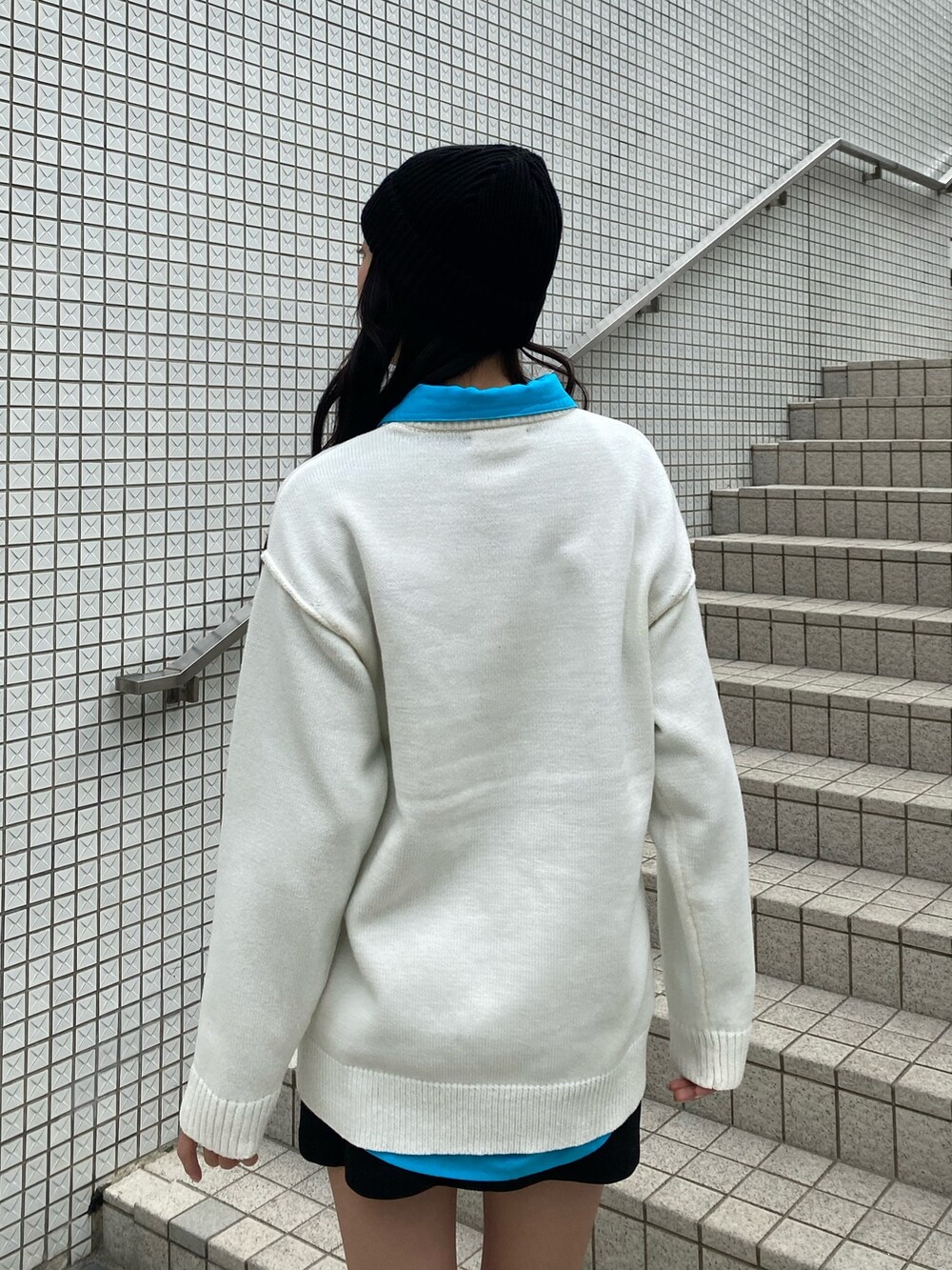 ブルー系のシャツ/ブラウス、ホワイト系のニット/セーター、ブラック系のスカートを着用したレディースの冬コーディネートの7枚目の写真