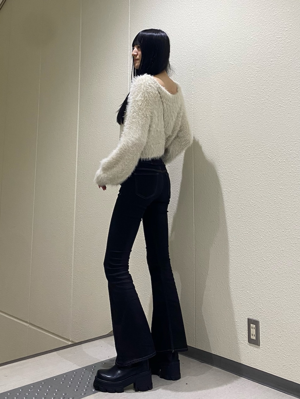 ホワイト系のニット/セーター、ブラック系のブーツ、ブラック系のデニムパンツを着用したレディースの冬コーディネートの3枚目の写真