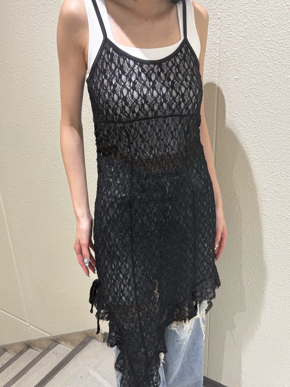 ホワイト系のニット/セーター、ブラック系のワンピース、ブルー系のデニムパンツを着用したレディースの夏コーディネートの6枚目の写真