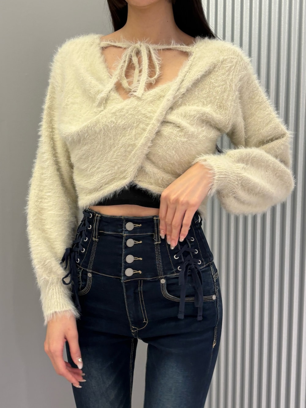 ブルー系のデニムパンツ、ブラック系のキャミソール、ホワイト系のニット/セーターを着用したレディースの秋コーディネートの6枚目の写真