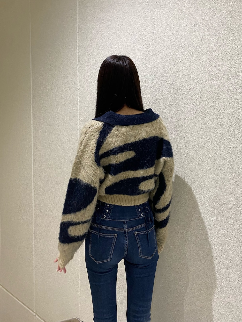 ブルー系のデニムパンツ、ブルー系のニット/セーター、ブラック系のブーツを着用したレディースの秋コーディネートの5枚目の写真