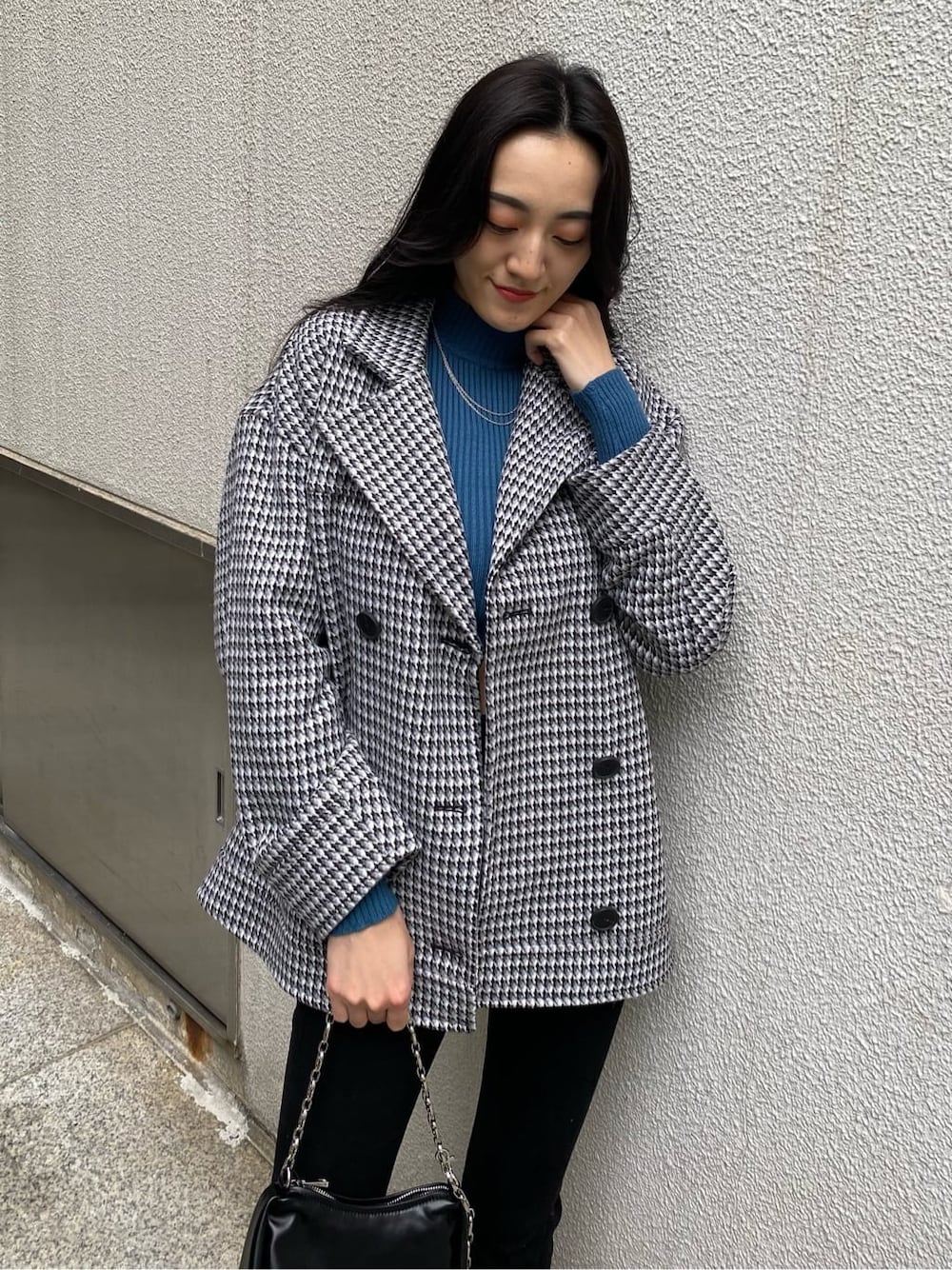 その他のテーラードジャケット、ブルー系のニット/セーター、ブラック系のハンドバッグを着用したレディースの秋コーディネートの5枚目の写真