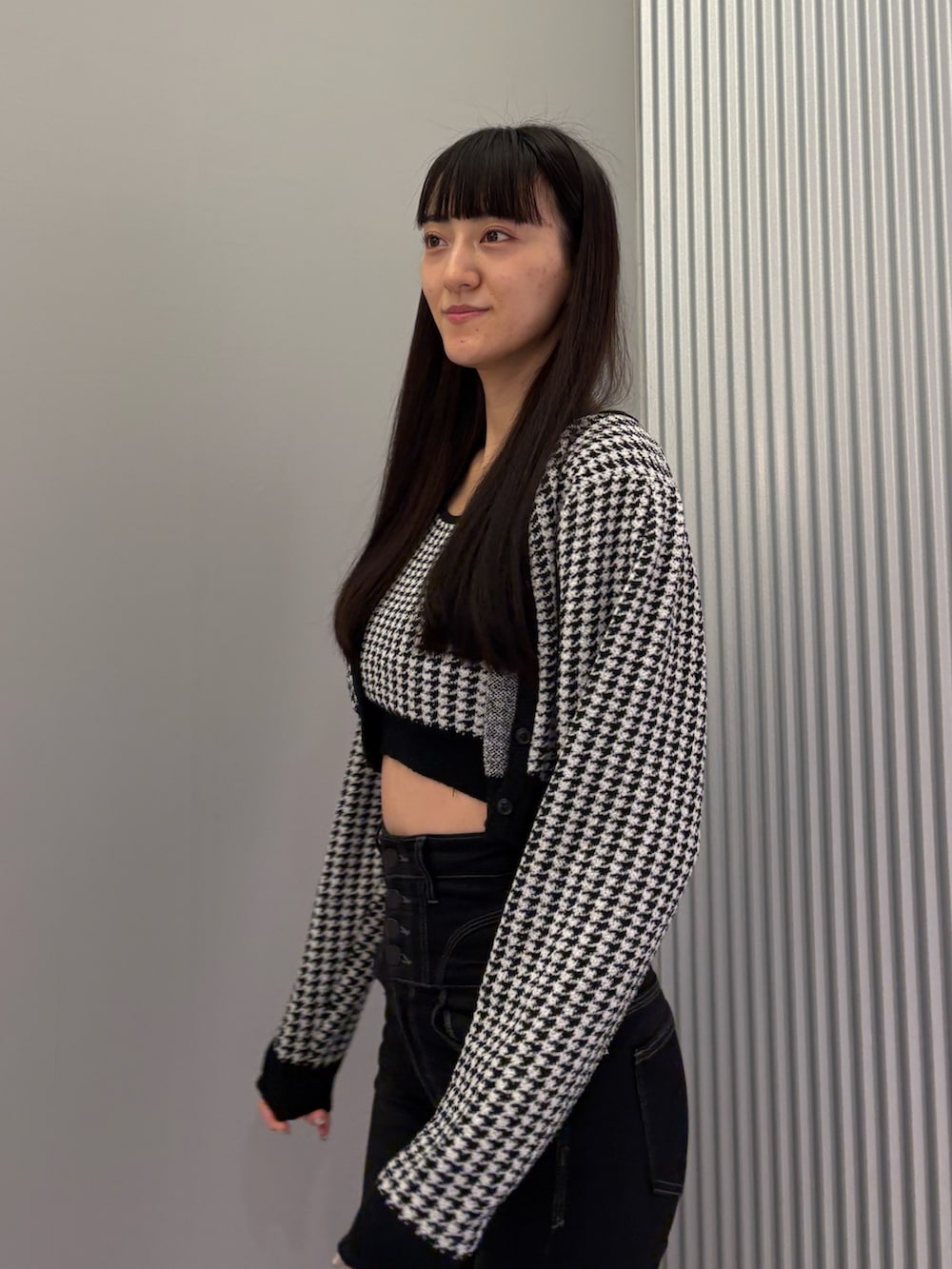 ブラック系のデニムパンツ、ブラック系のニット/セーター、ブラック系のブーツを着用したレディースの秋コーディネートの8枚目の写真