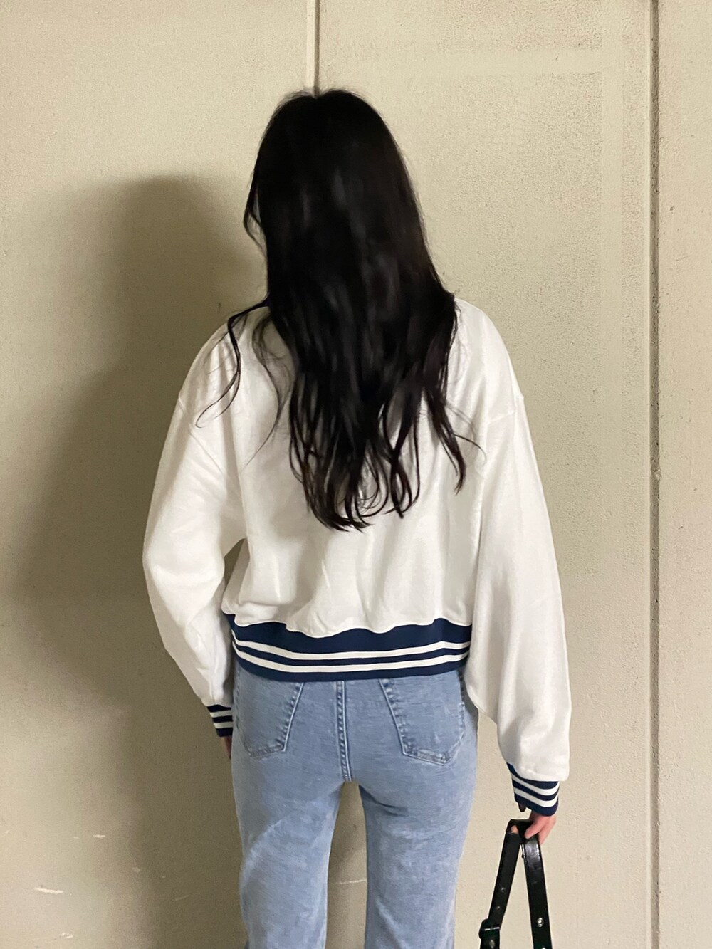 ホワイト系のTシャツ/カットソー、ブルー系のデニムパンツ、ブラック系のブーツを着用したレディースの春コーディネートの7枚目の写真