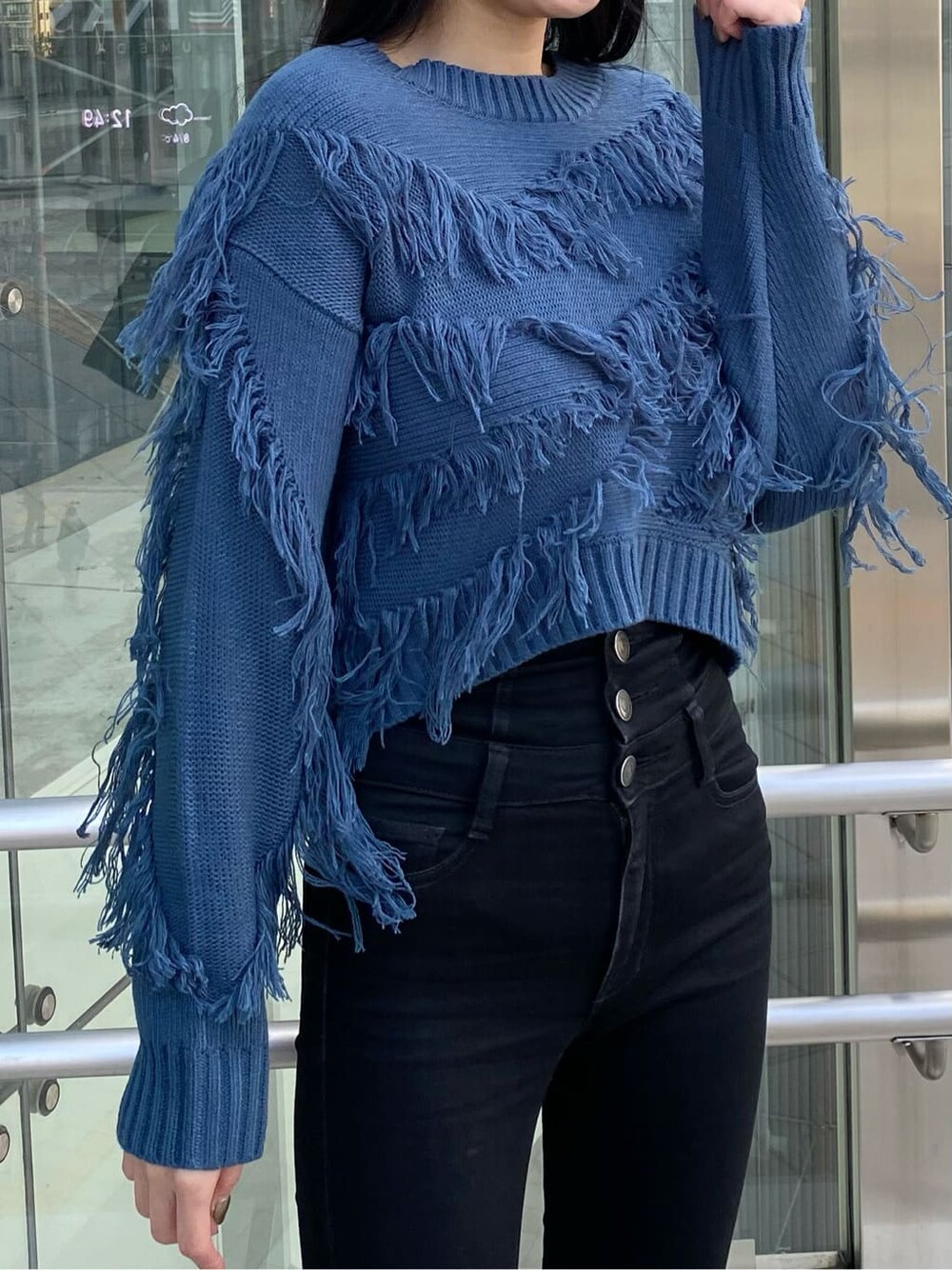 ブラック系のデニムパンツ、ブラック系のダウンジャケット/コート、ブルー系のニット/セーターを着用したレディースの冬コーディネートの7枚目の写真