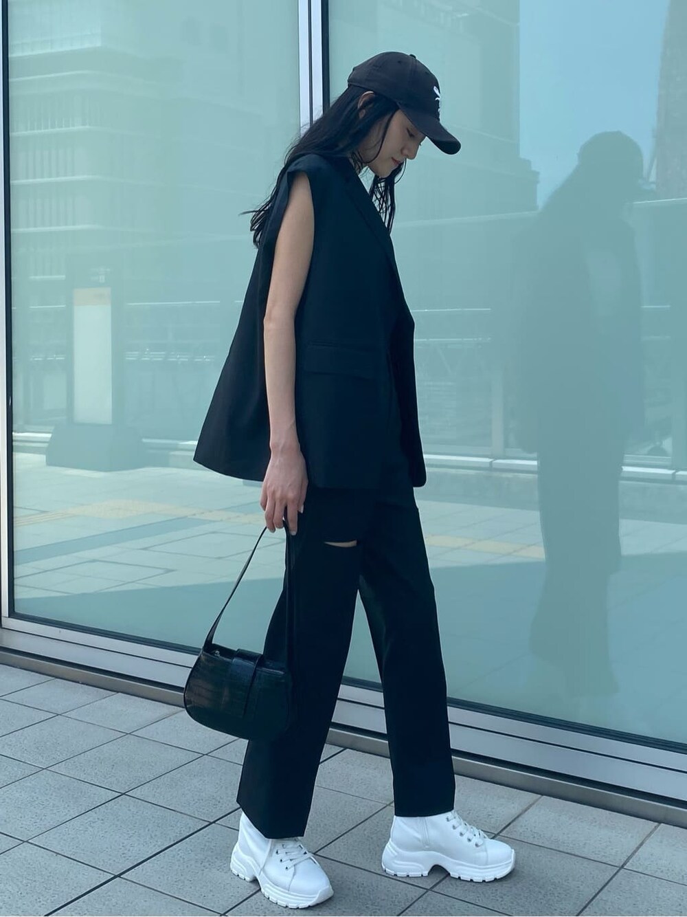 ホワイト系のスニーカー、ブラック系のベスト、ブラック系のその他パンツを着用したレディースの夏コーディネートの3枚目の写真