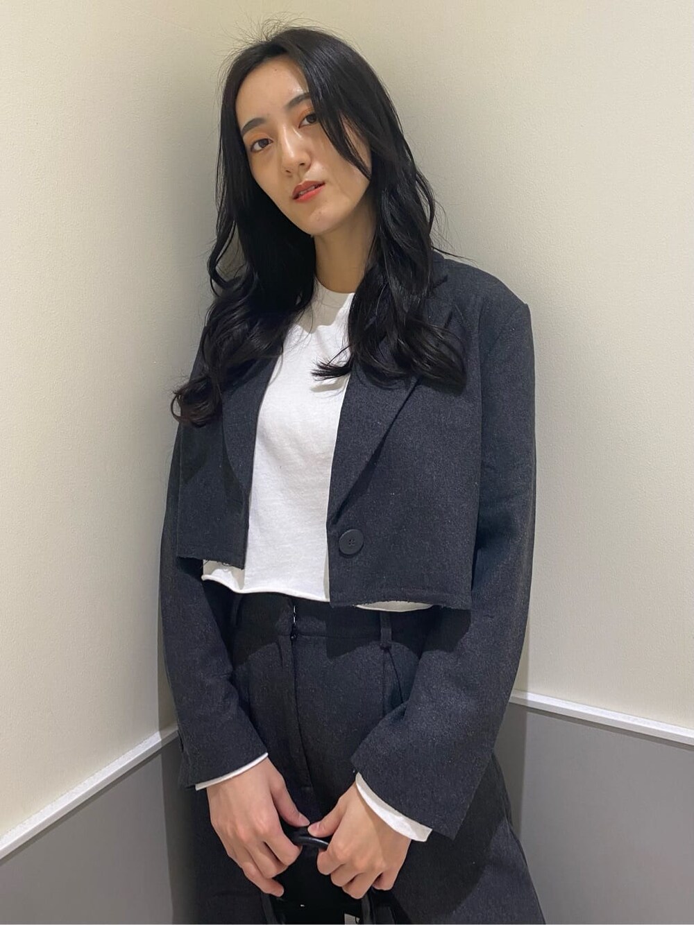 グレー系のテーラードジャケット、グレー系のその他パンツ、ブラック系のハンドバッグを着用したレディースの秋コーディネートの7枚目の写真