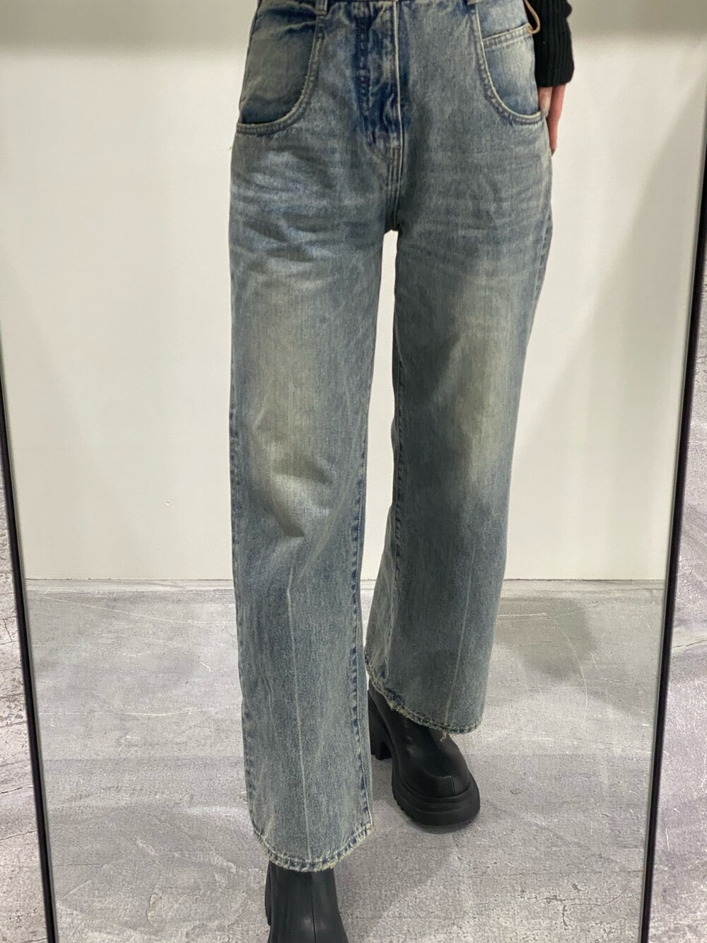 ブルー系のデニムパンツ、ブラック系のニット/セーター、ブラック系のブーツを着用したレディースの冬コーディネートの5枚目の写真