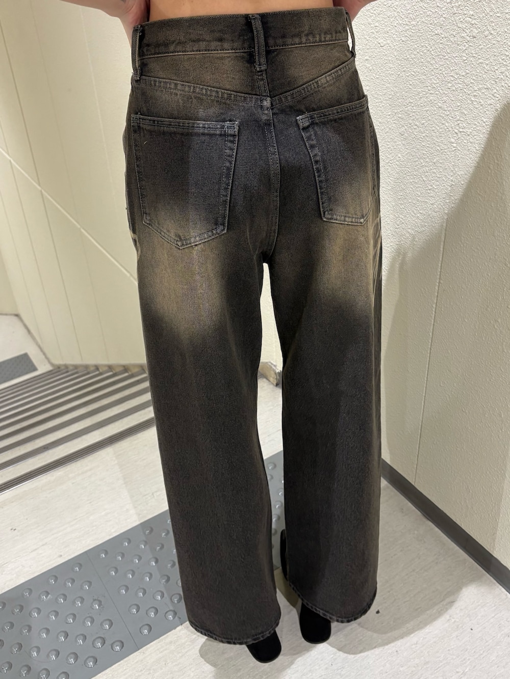 ブラック系のデニムパンツ、ブルー系のTシャツ/カットソー、ブラック系のサンダルを着用したレディースの夏コーディネートの8枚目の写真