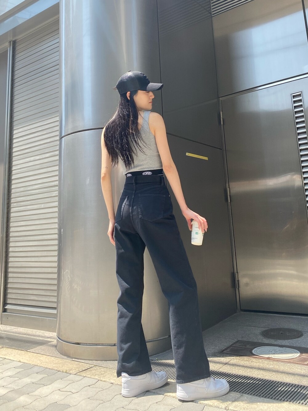 ブラック系のデニムパンツ、グレー系のTシャツ/カットソー、ブラック系のキャップを着用したレディースの夏コーディネートの3枚目の写真
