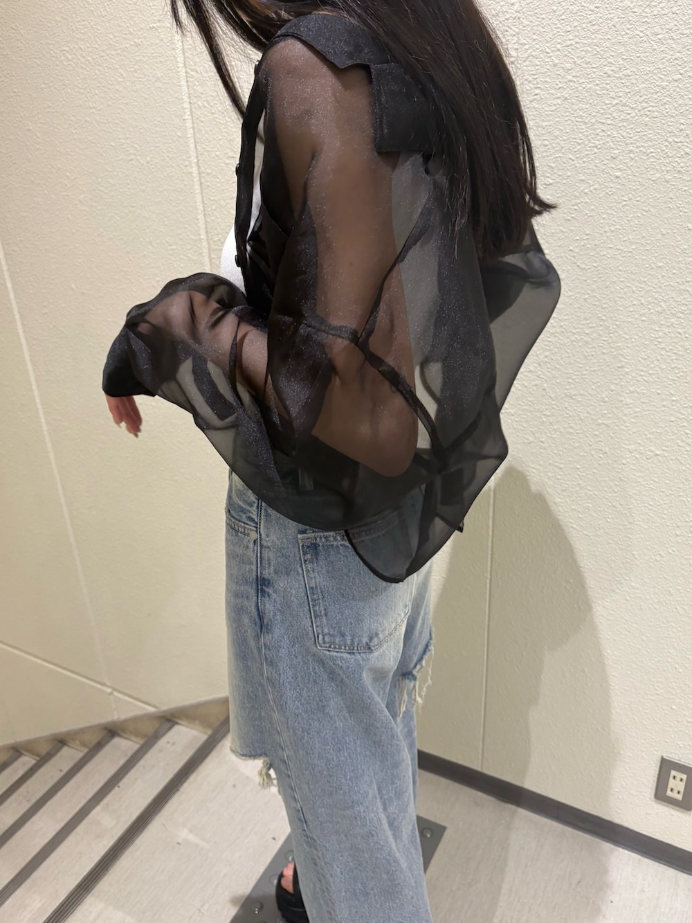 ホワイト系のニット/セーター、ブルー系のデニムパンツ、ブラック系のシャツ/ブラウスを着用したレディースの夏コーディネートの7枚目の写真