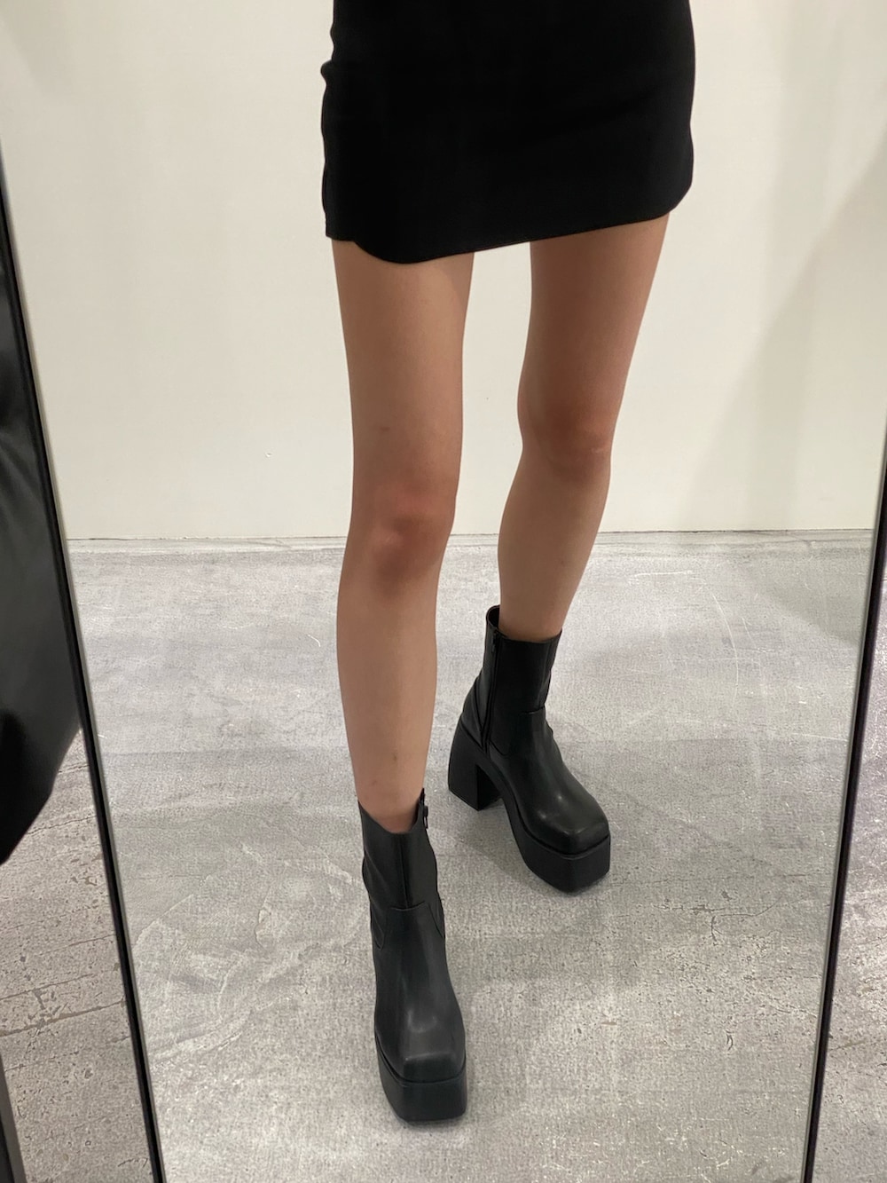 ブラック系のスカート、ブラック系のブーツ、ブルー系のニット/セーターを着用したレディースの秋コーディネートの7枚目の写真