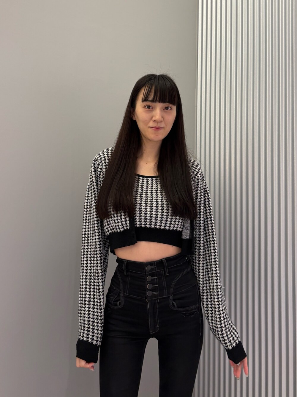 ブラック系のデニムパンツ、ブラック系のニット/セーター、ブラック系のブーツを着用したレディースの秋コーディネートの6枚目の写真