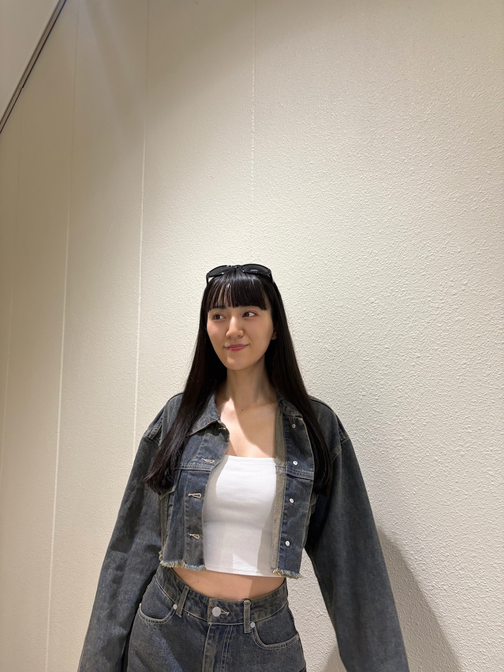 ブルー系のスカート、ブルー系のデニムジャケット、ホワイト系のキャミソールを着用したレディースの夏コーディネートの5枚目の写真