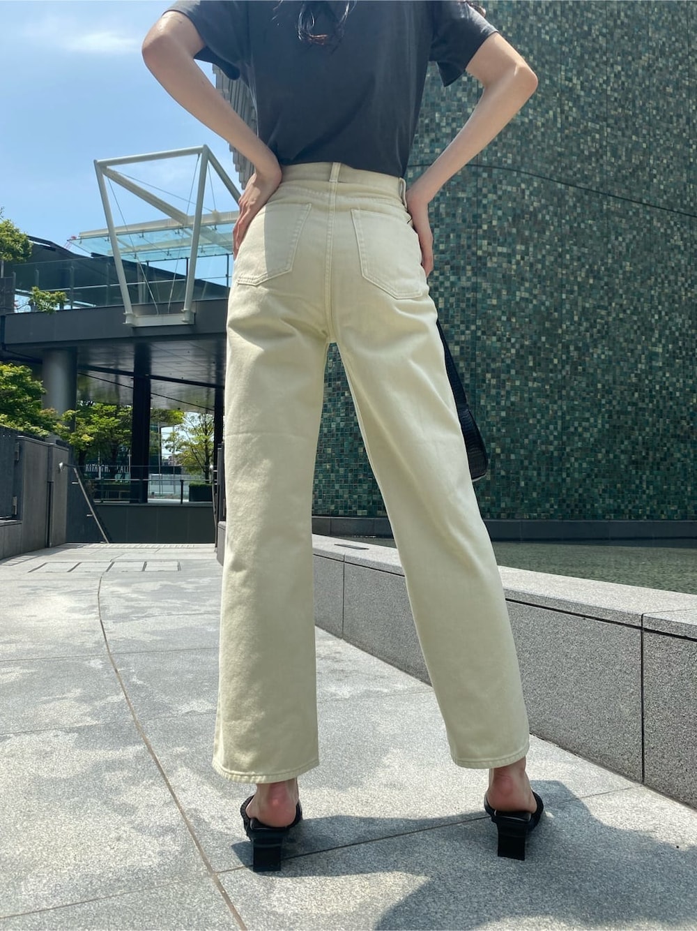 ホワイト系のデニムパンツ、ブラック系のサンダル、ブラック系のハンドバッグを着用したレディースの夏コーディネートの7枚目の写真