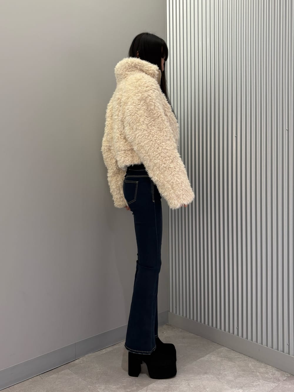 ブルー系のデニムパンツ、ホワイト系のブルゾン、グレー系のニット/セーターを着用したレディースの秋コーディネートの4枚目の写真