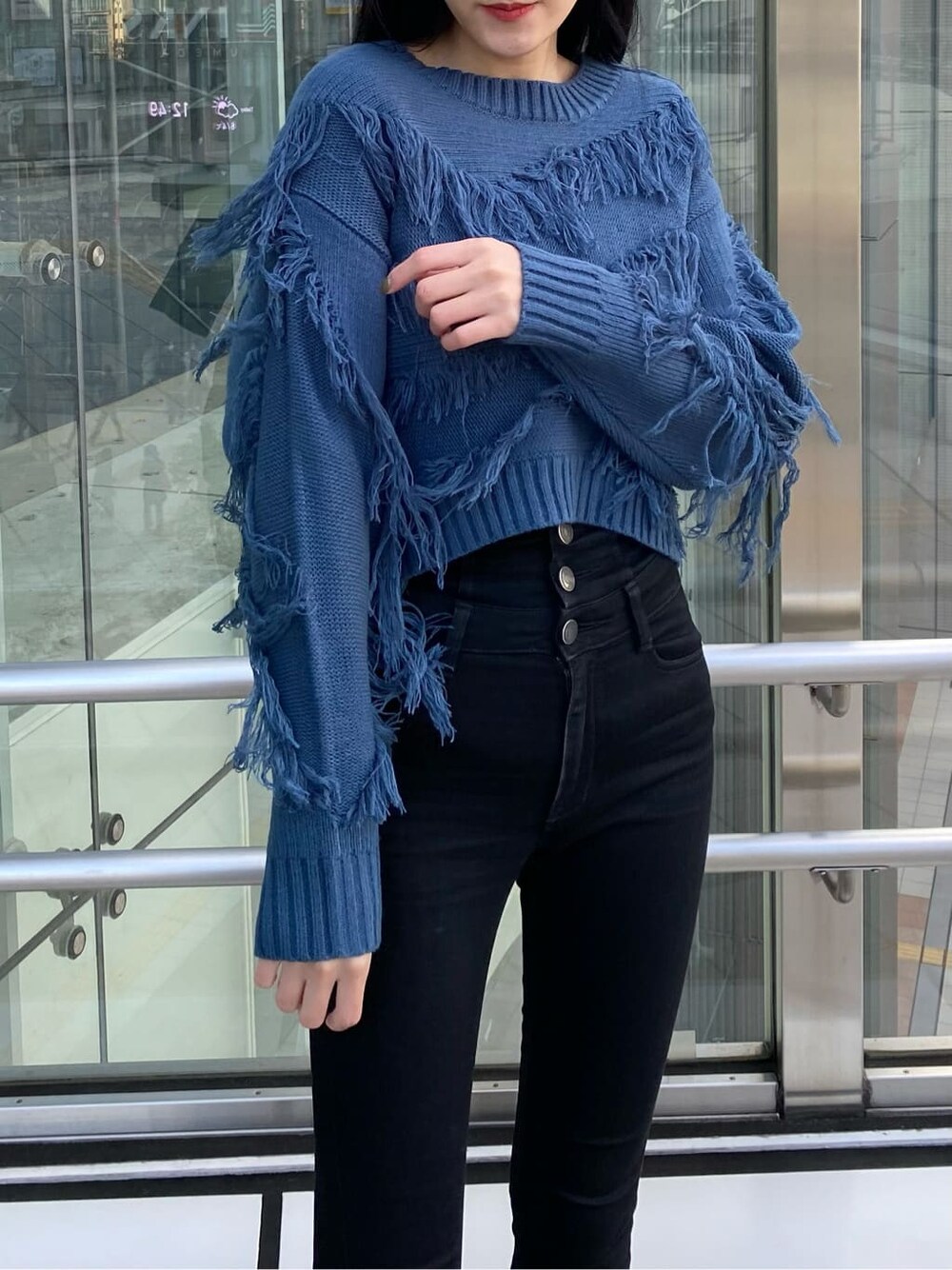 ブラック系のデニムパンツ、ブラック系のダウンジャケット/コート、ブルー系のニット/セーターを着用したレディースの冬コーディネートの6枚目の写真