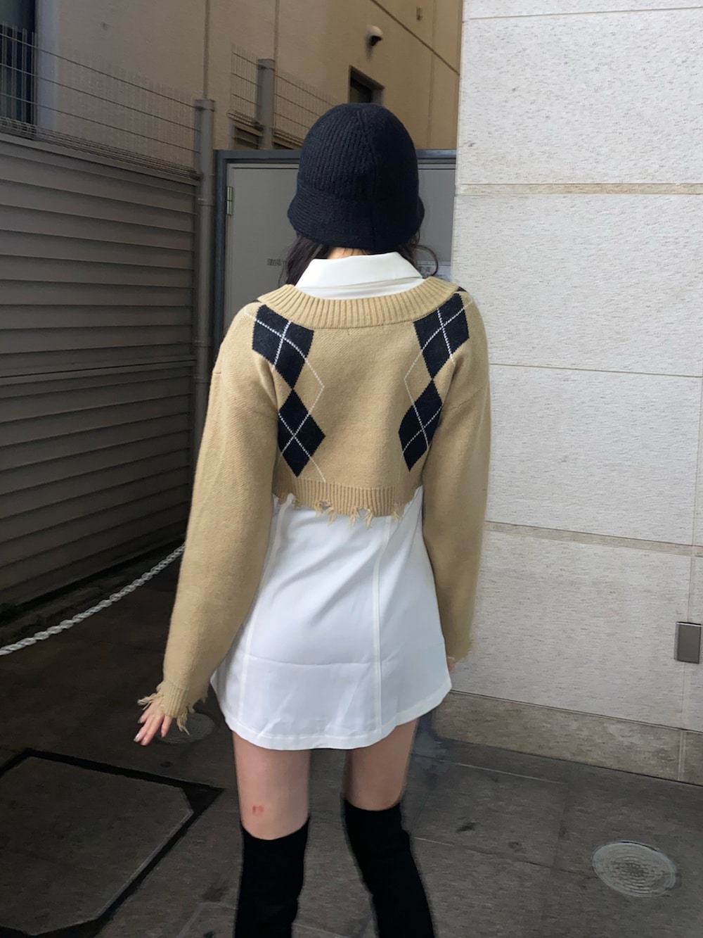 その他のニット/セーター、ホワイト系のワンピース、ブラック系のブーツを着用したレディースの冬コーディネートの5枚目の写真